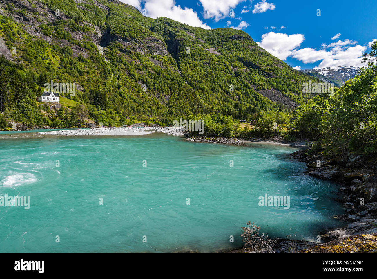 Jostedalen valle, il ghiacciaio del fiume e mountainscape, Norvegia, con casa in riva al fiume, Jostedalsbreen Parco Nazionale Foto Stock