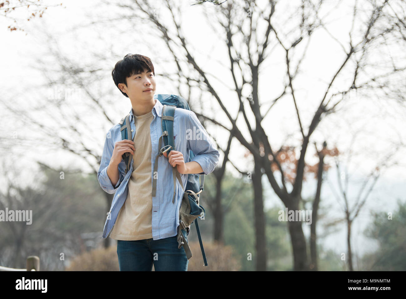 Un giovane uomo che fa un viaggio zaino in spalla in una tradizionale coreano house. Foto Stock