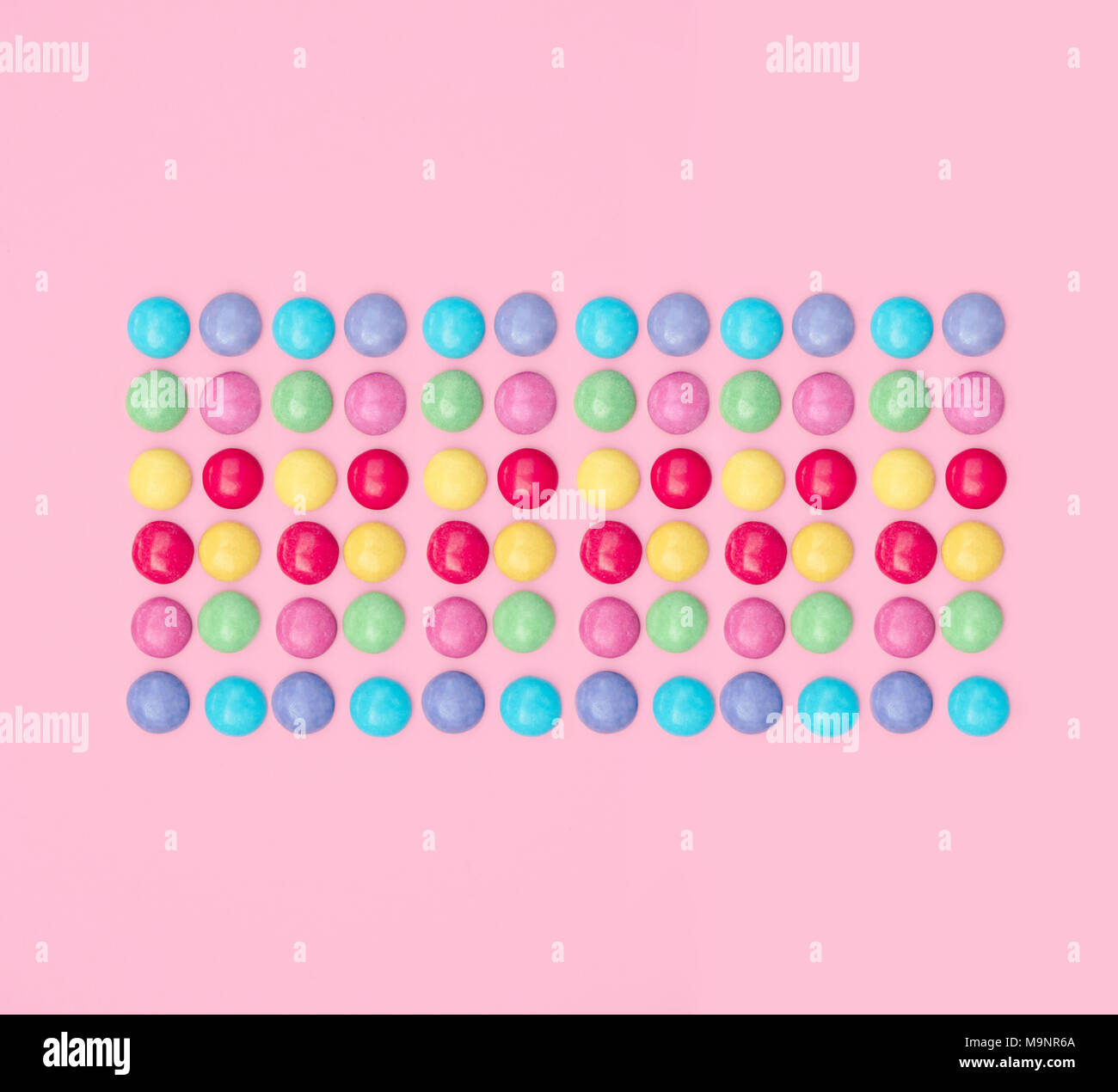 Un assortimento di caramelle colorate su sfondo rosa. Foto Stock