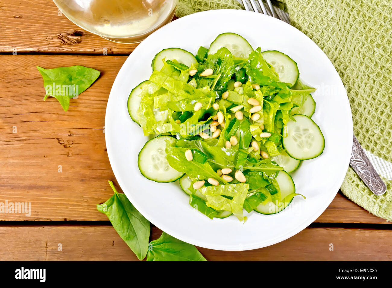 Insalata Di Spinaci Cetrioli Freschi Rukkola Insalata Dadi Di Cedro E Cipolline Condito Con Olio Vegetale Su Una Piastra Igienico E Forcella Su Un Di Legno Foto Stock Alamy