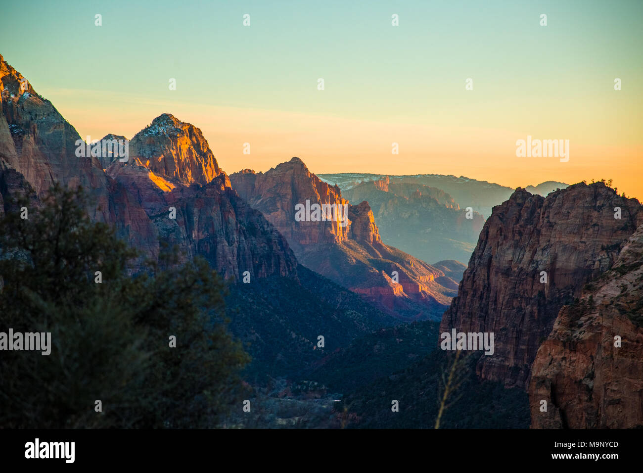 Bella arancio e blu tramonto sopra le cime delle montagne del Parco Nazionale di Zion, Utah durante l'estate. Foto Stock