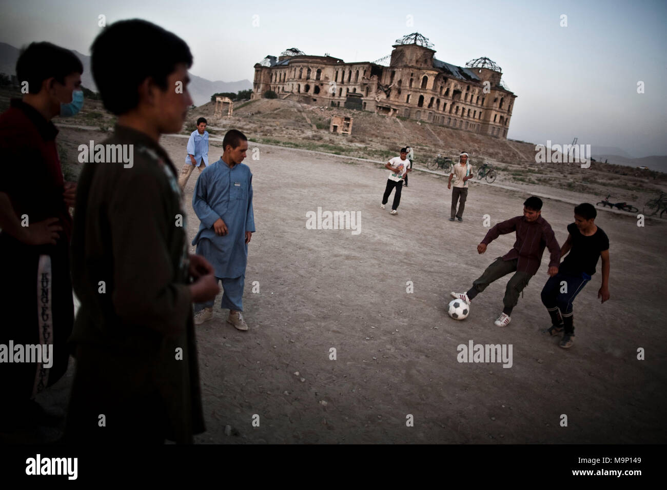 Afghan ragazzi giocare a calcio come ha bombardato il Darul Aman Palace che sta per "dimora di pace", distrutto durante la guerra civile a Kabul, Afghanistan, mercoledì 15 luglio, 2009. Foto Stock