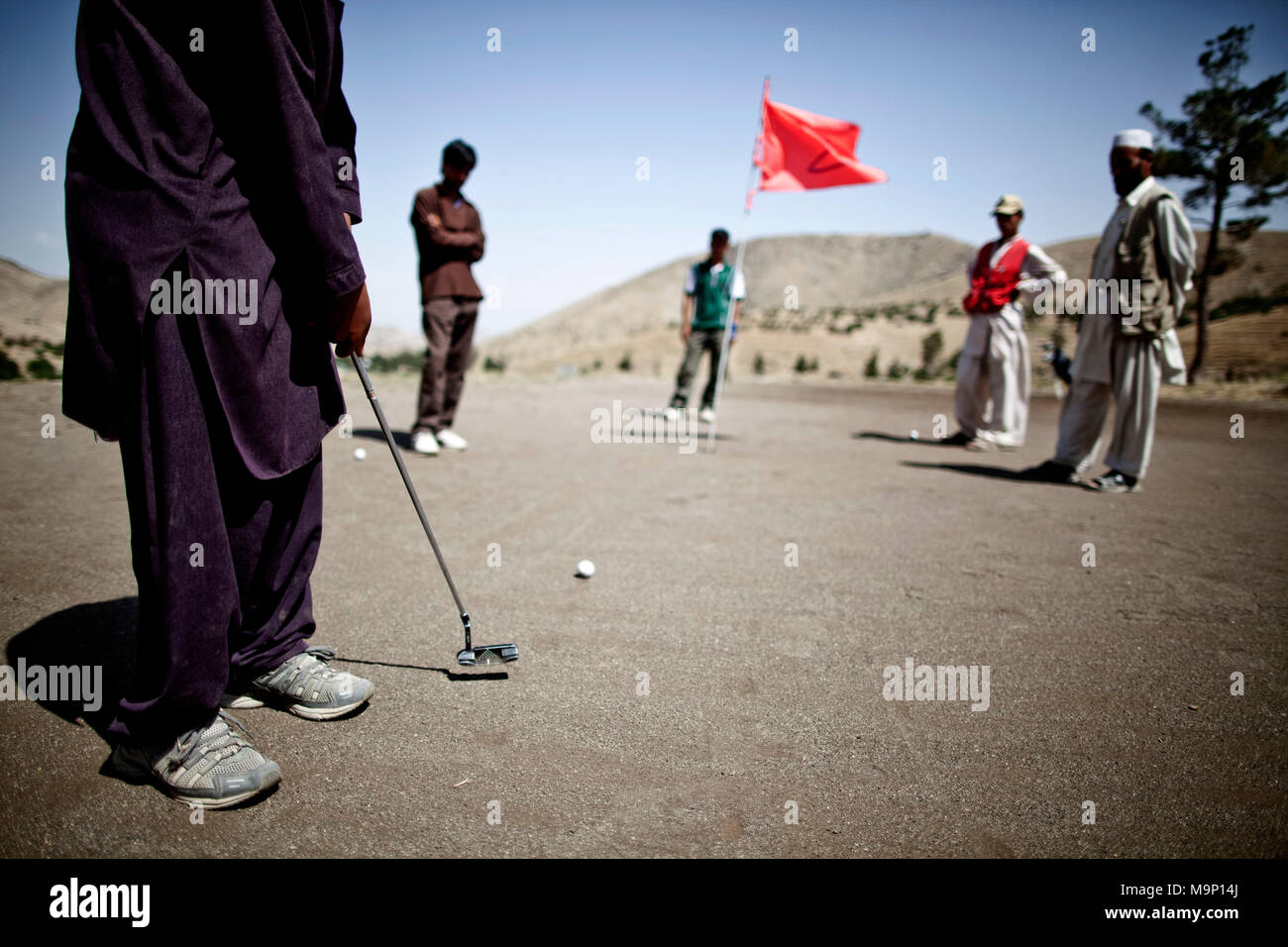 Un Afghan golf putt nel secondo foro a Kabul Golf Club a Kabul, Afghanistan, luglio 17, 2009. Questo è l'unico campo da golf a Kabul e ha riaperto nel 2003. Foto Stock