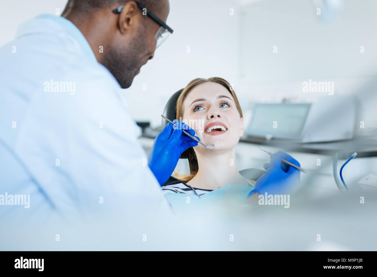 Pretty Woman a ridere con il suo dentista durante il checkup Foto Stock