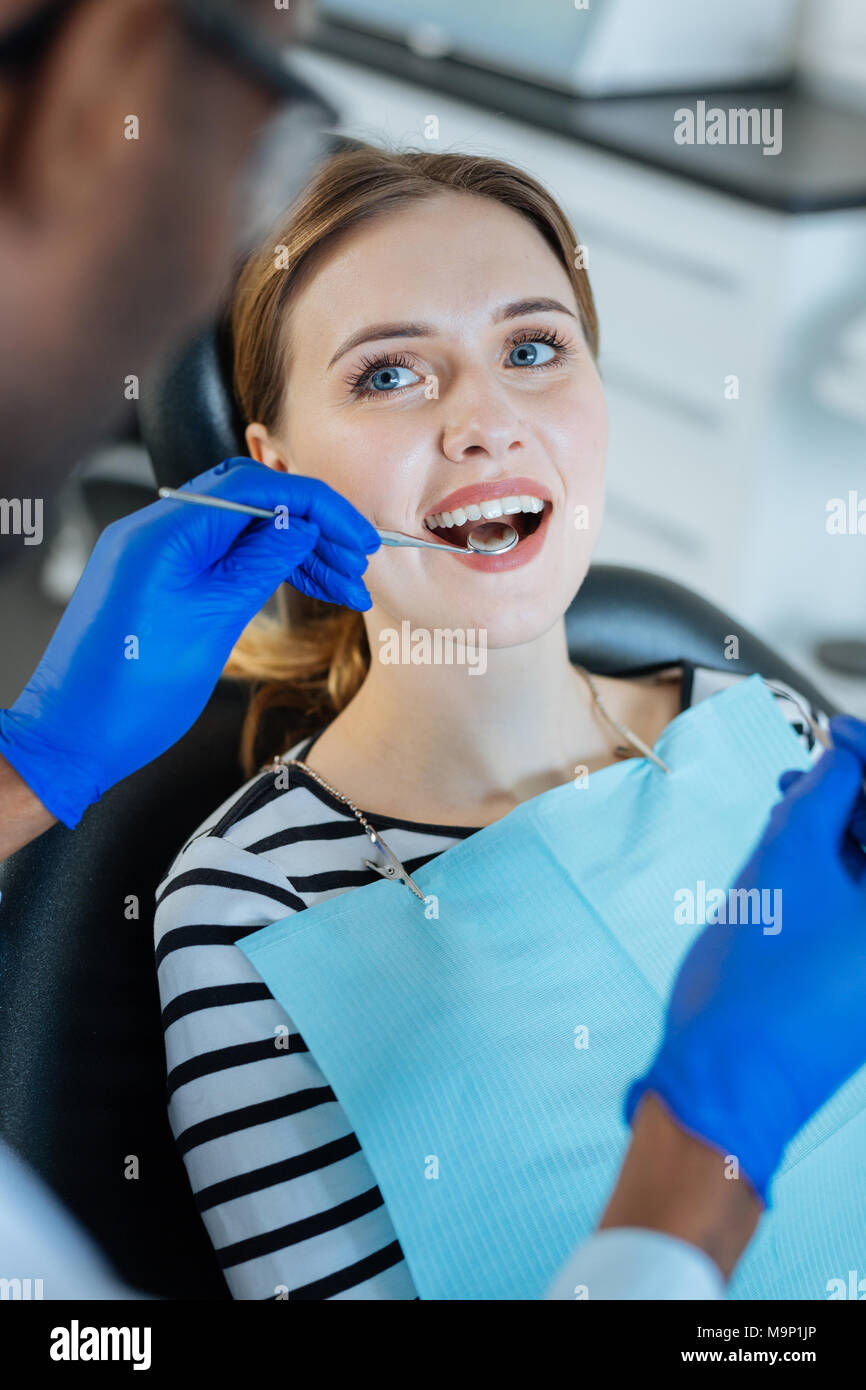 Bella donna avente i suoi denti esaminati dal dentista Foto Stock