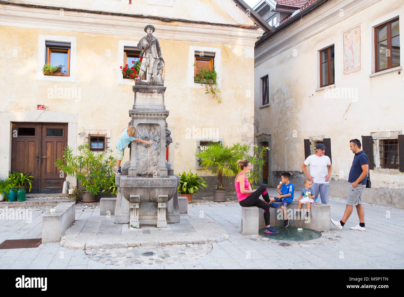 La gente del posto appendere fuori su Linhartov Trg, la coloratissima piazza principale di Radovljica, Slovenia Foto Stock