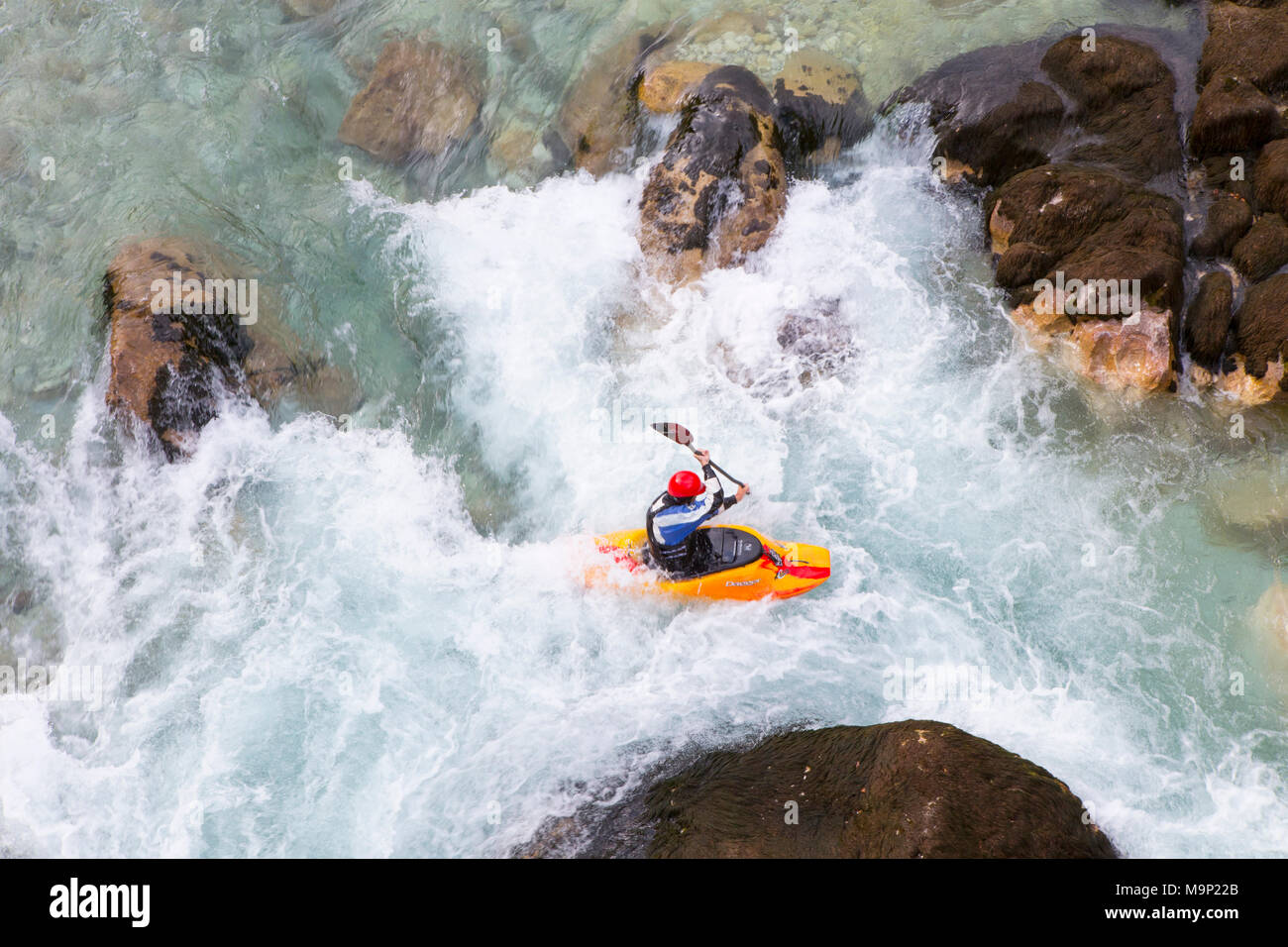 Kayaker maschio incrocio idromassaggio nel colore verde Soca river vicino a Bovec, Slovenia Foto Stock