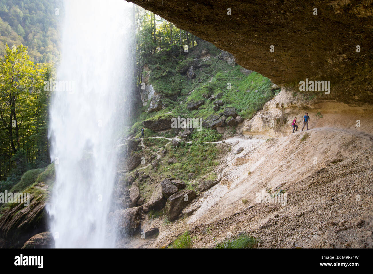 Due persone che camminano su sentiero dietro la cascata Pericnik in alpine valle di Vrata vicino a Mojstrana nel Parco Nazionale del Triglav, Slovenia Foto Stock