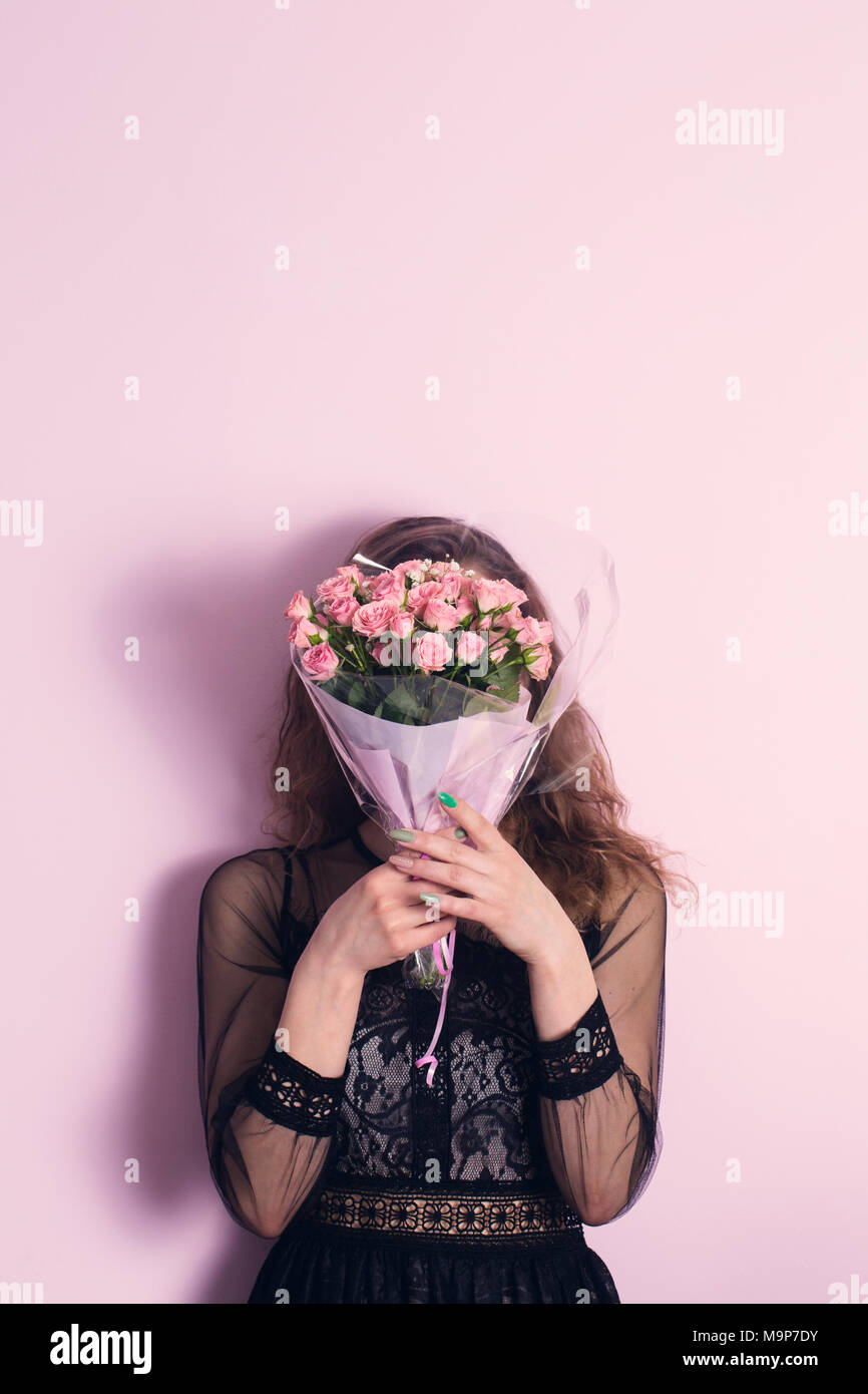 La ragazza il viso coperto con un bouquet Foto stock - Alamy