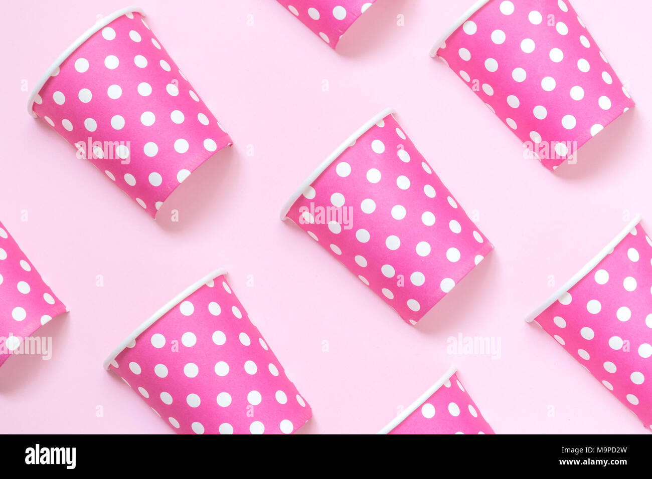 Bicchieri di carta polka design pattern sul rosa pastello minima di sfondo concetto creativo. Foto Stock