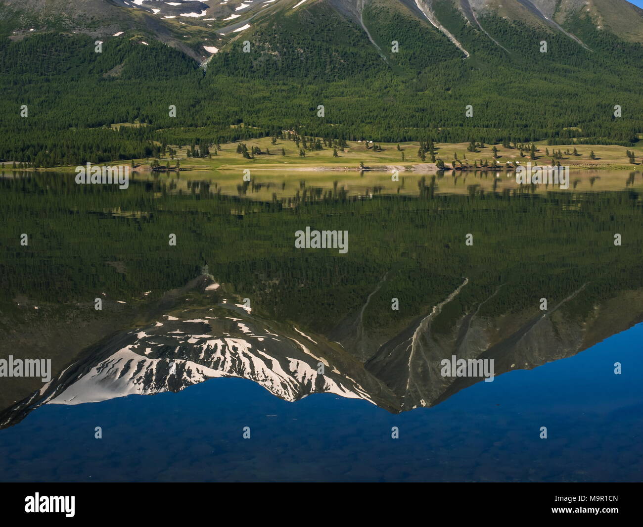 Lago Khoton con il verde paesaggio forestale e acqua la riflessione di montagne coperte di neve e Mongolia Foto Stock