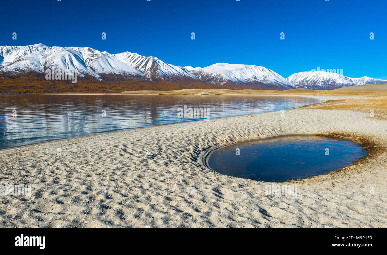 Spiaggia di sabbia attrezzata con piscina, Khoton lago, le montagne ricoperte di neve nella parte posteriore, Mongolia Foto Stock