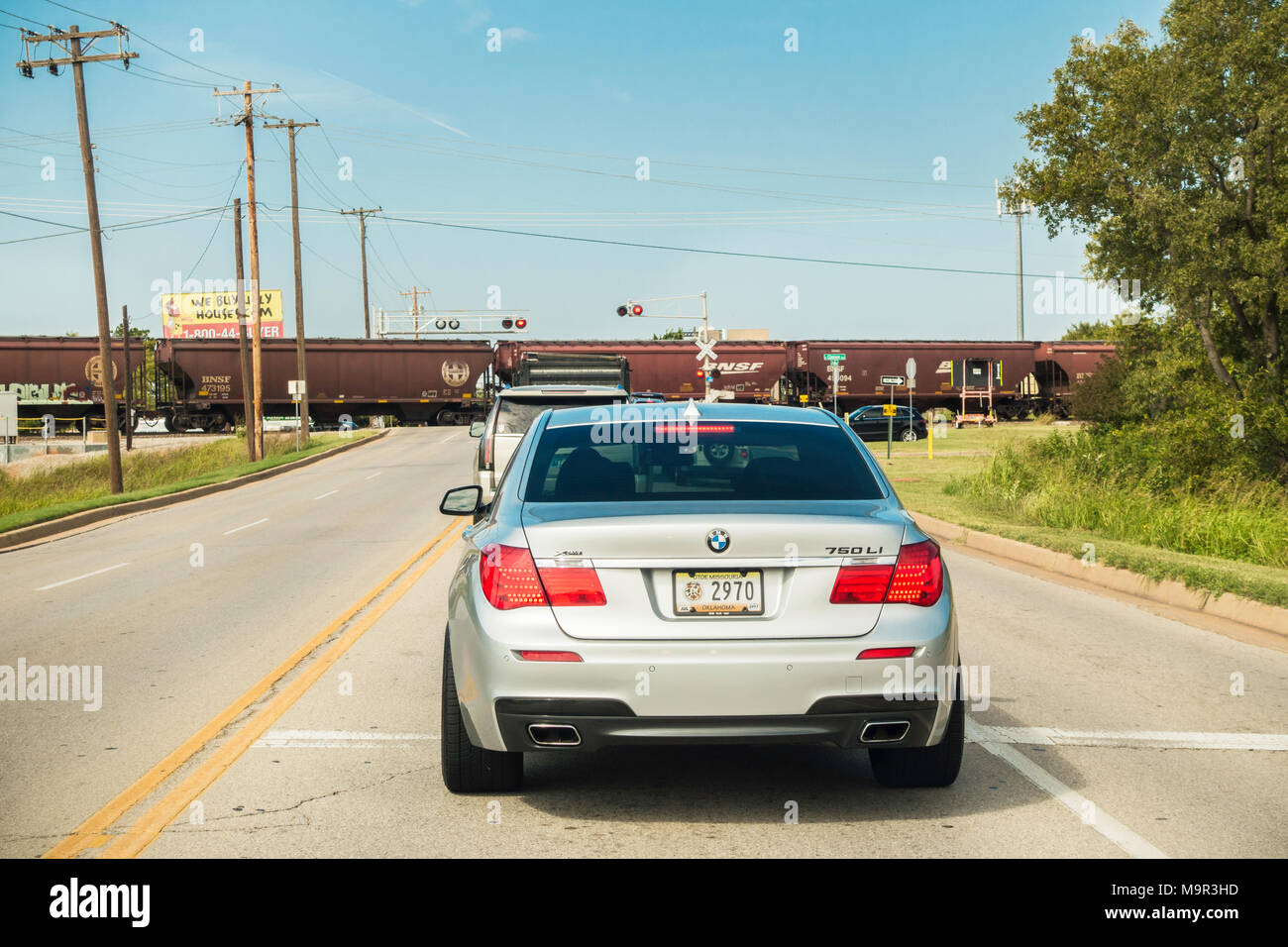 Una linea di automobili in attesa di un treno per attraversare la strada in Oklahoma City, Oklahoma, Stati Uniti d'America. Foto Stock