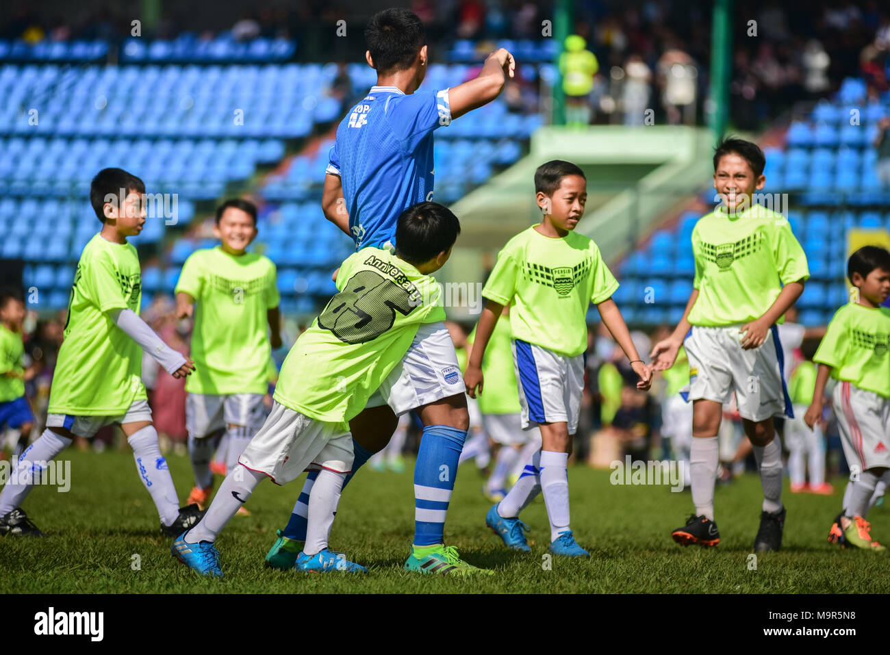 Un bambino player facendo un "all'uomo marcatura " durante un match di esibizione a celebrare Persib FC's ottantacinquesimo anniversario a Bandung, Indonesia. Foto Stock