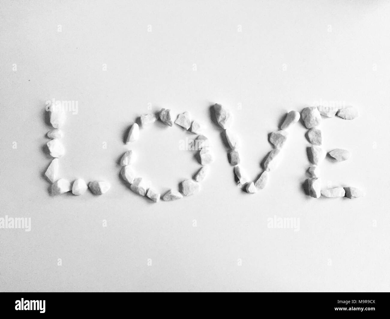 Cuore di ciottoli intagliato su uno sfondo di sabbia. Può essere utilizzato come sfondo Foto Stock