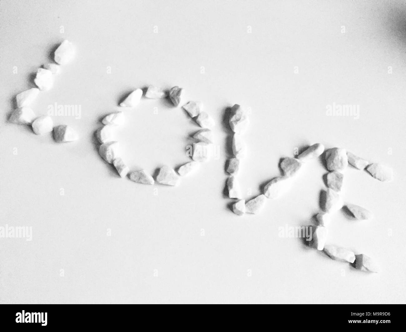 Cuore di ciottoli intagliato su uno sfondo di sabbia. Può essere utilizzato come sfondo Foto Stock