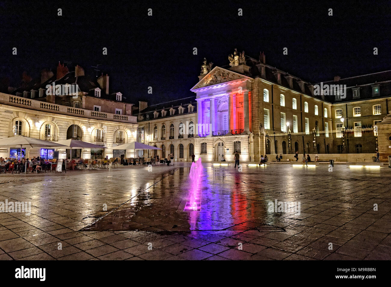 Di notte a luogo Liberacion, Dijon, Borgogna con fontane e piazza illuminata con i colori della bandiera francese. Foto Stock