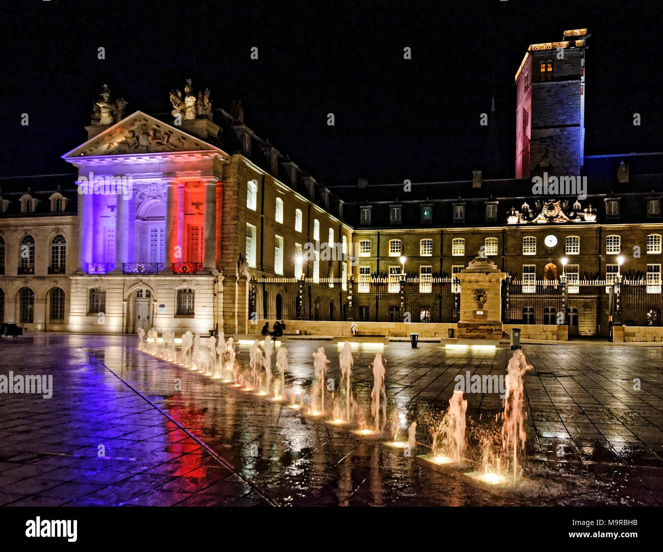 Di notte a luogo Liberacion, Dijon, Borgogna con fontane e piazza illuminata con i colori della bandiera francese. Foto Stock