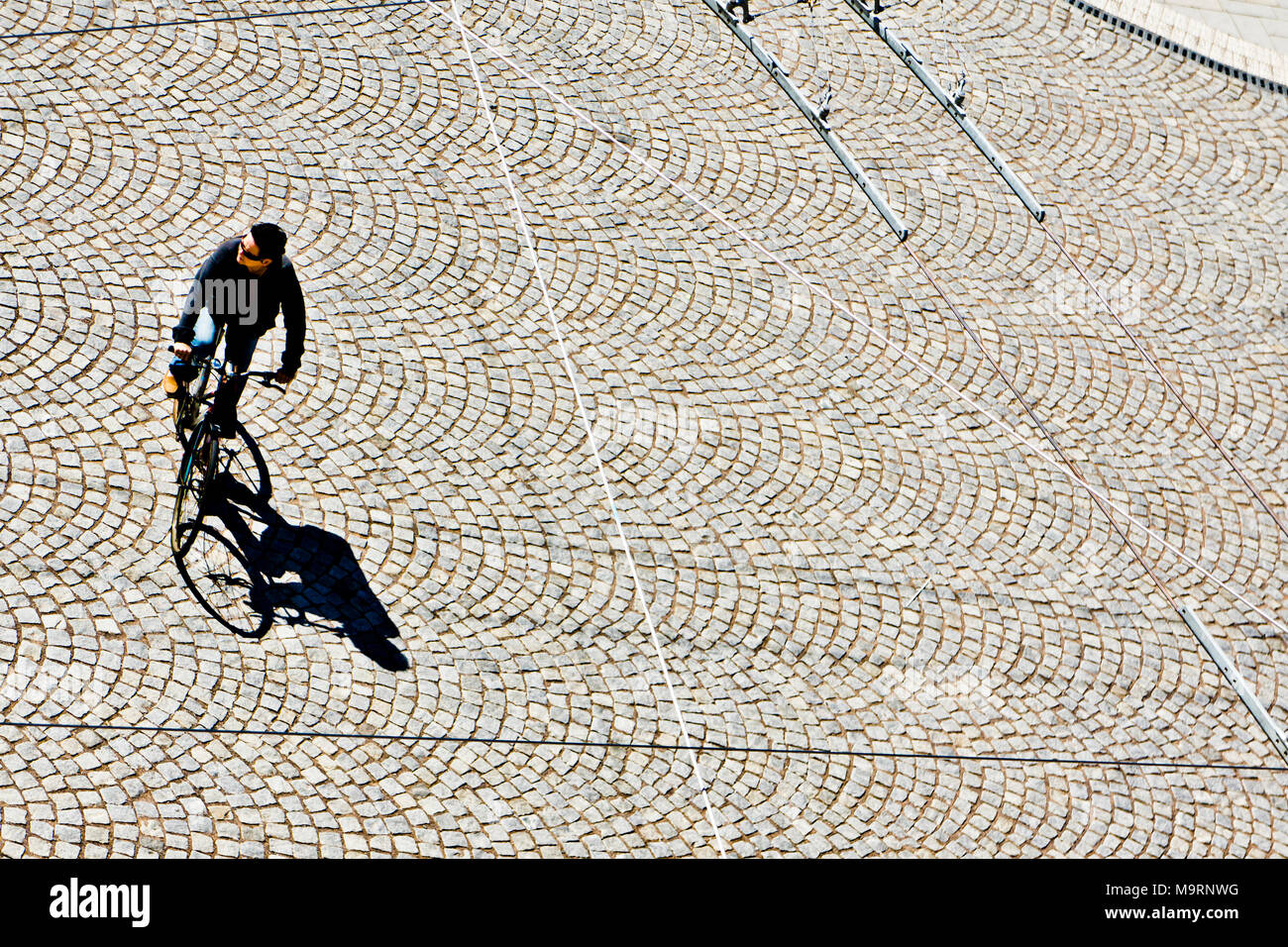 Uomo in sella ad una bicicletta in una strada di città, vista da sopra Foto Stock