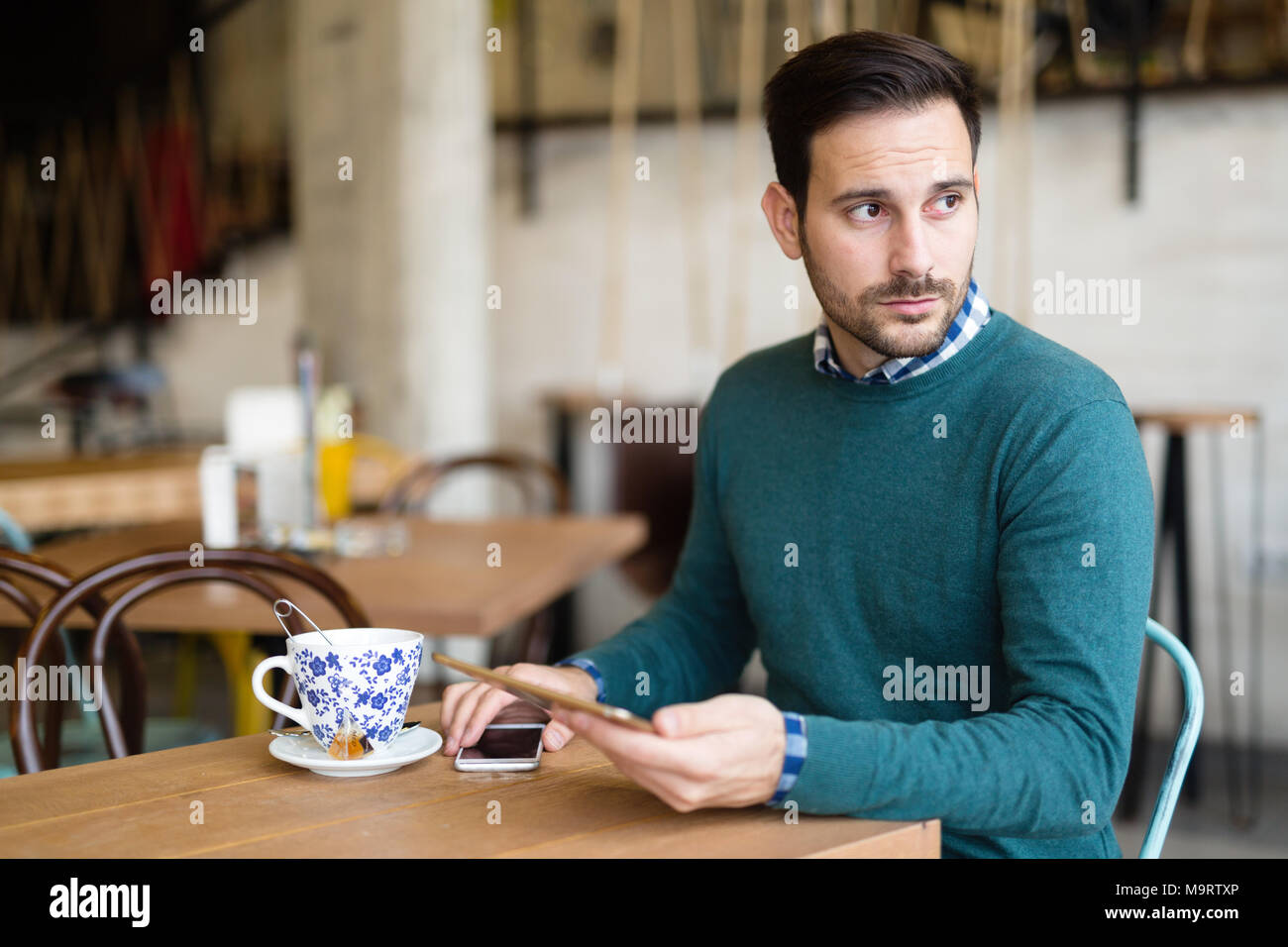 Ritratto di giovane uomo attraente utilizzando tablet Foto Stock