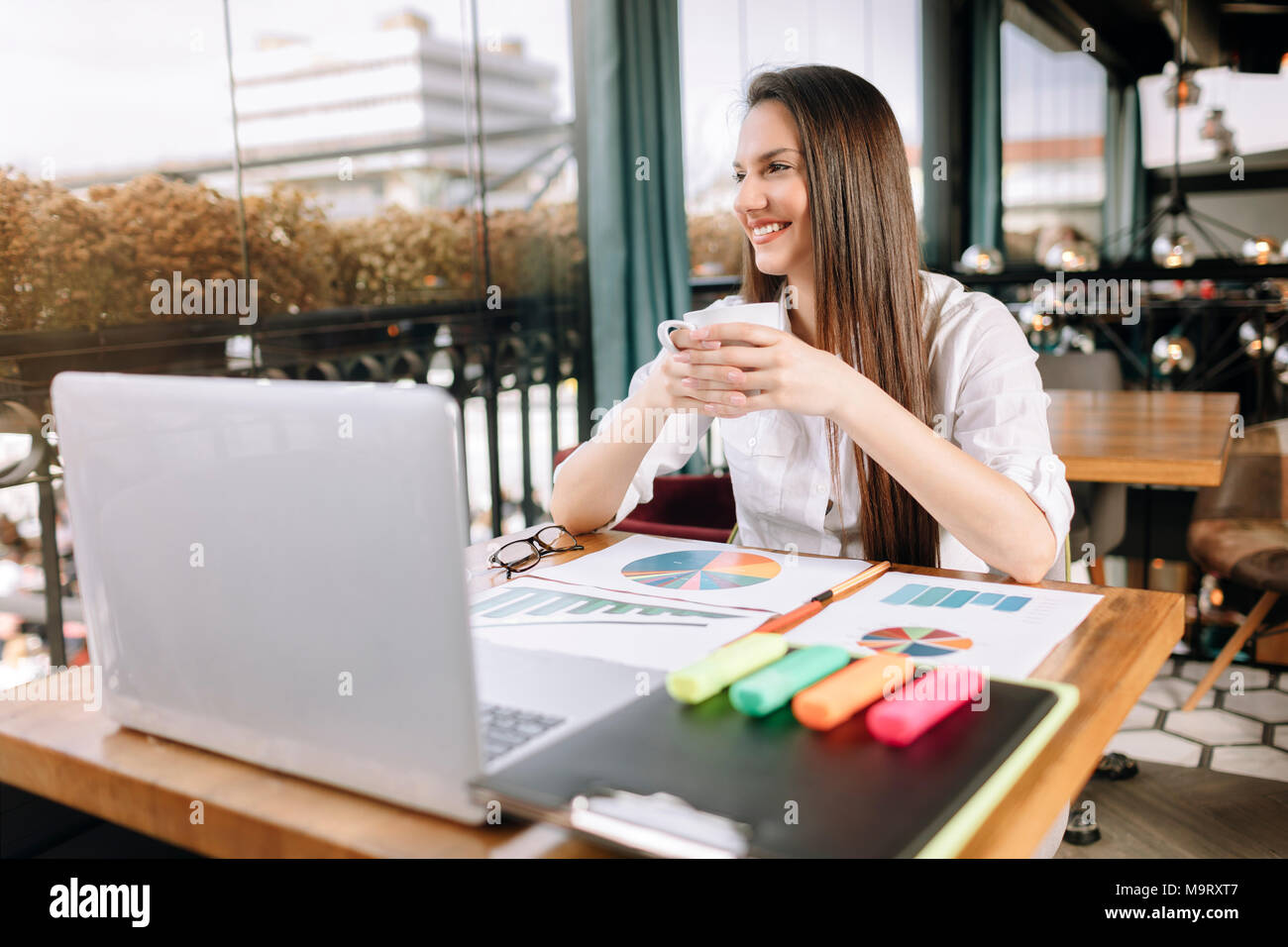 Imprenditrice o giovani femmine con gli occhiali facendo pausa caffè al lavoro. Caffè il concetto di rilassamento. Foto Stock