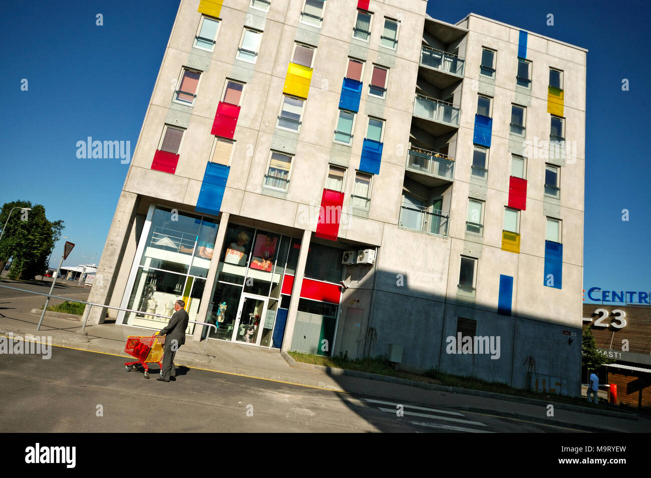 Uomo con un carrello per supermercati e edificio colorato a Tallinn in Estonia Foto Stock