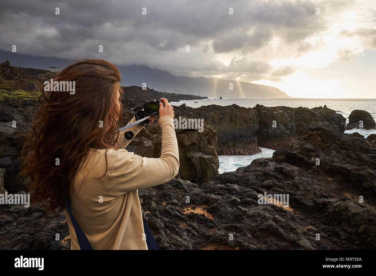 Ragazza fotografare una vista panoramica della costa del mare in La Frontera golfo, a El Hierro Island (Isole Canarie) Foto Stock