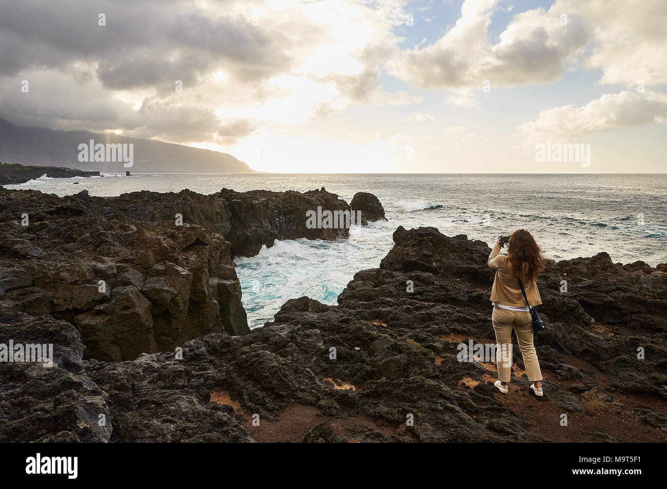 Ragazza fotografare una vista panoramica della costa del mare in La Frontera golfo, a El Hierro Island (Isole Canarie) Foto Stock