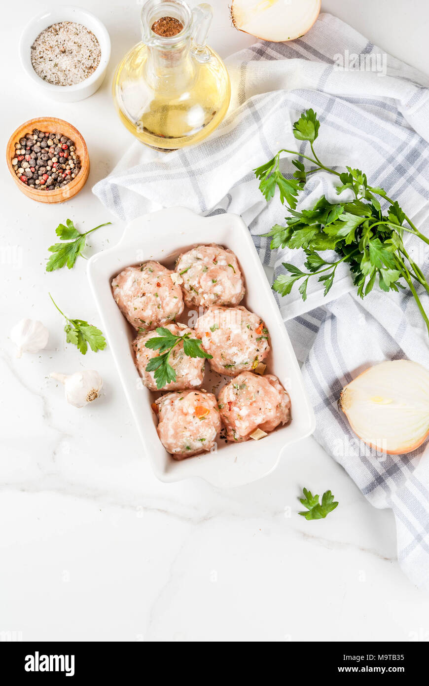 Materie in casa di pollo o la Turchia le polpette di carne in una teglia su marmo bianco dello sfondo. Copia spazio. vista superiore Foto Stock