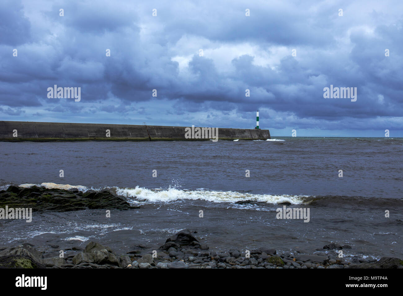 Il molo di pietra con la tempesta che sopraggiungono in Aberystwyth Ceredigion REGNO UNITO Galles Foto Stock