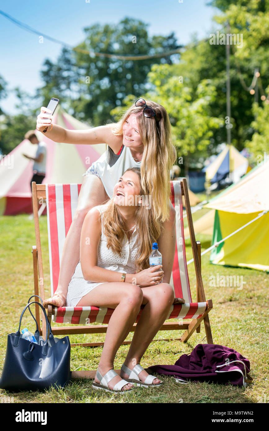 Ragazze prendere un selfie in un 'Glamping' area a Cornbury Music Festival Regno Unito Foto Stock