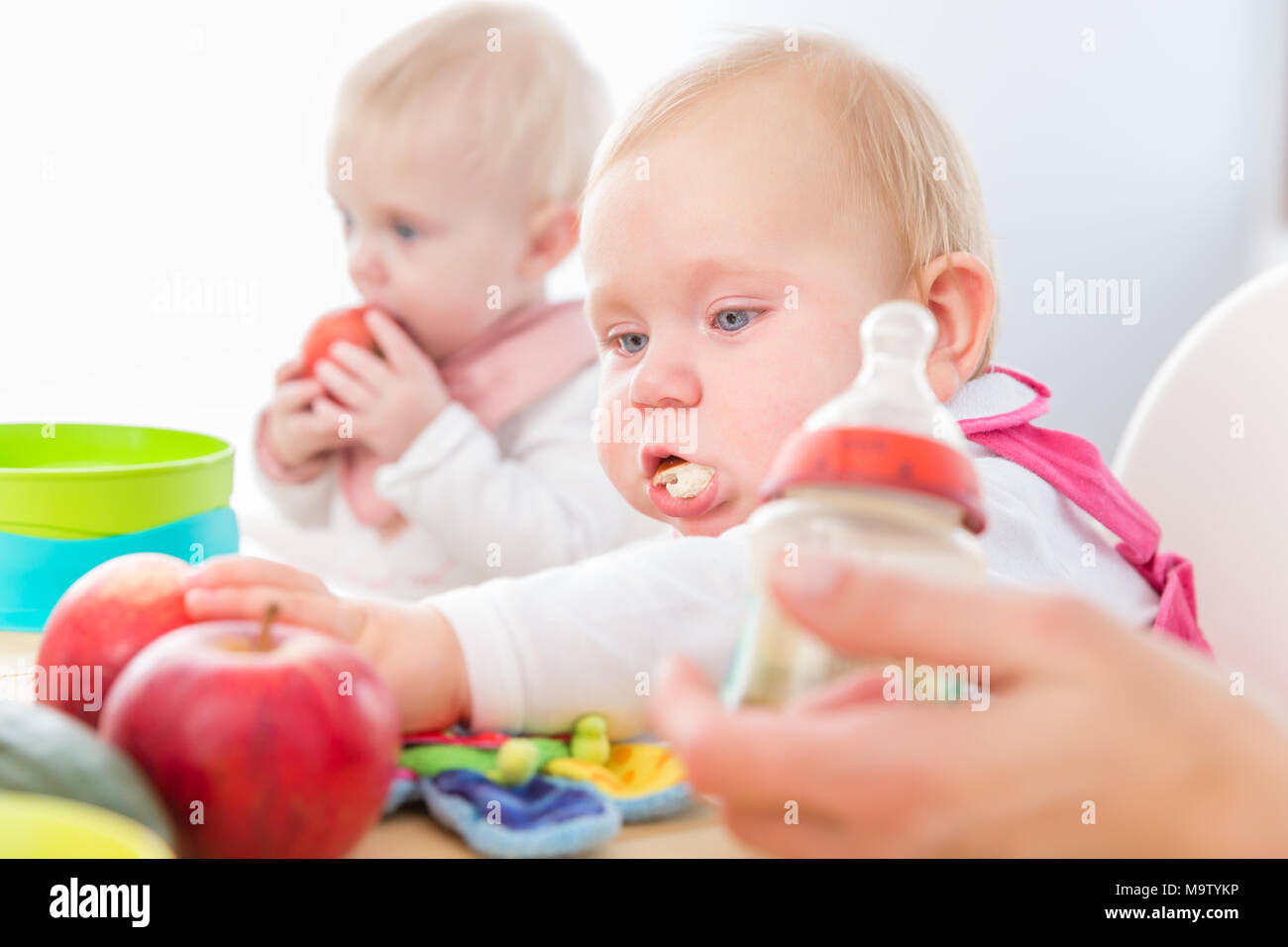 Carino Baby girl mangiare sano cibo solido in un moderno centro di assistenza diurna Foto Stock