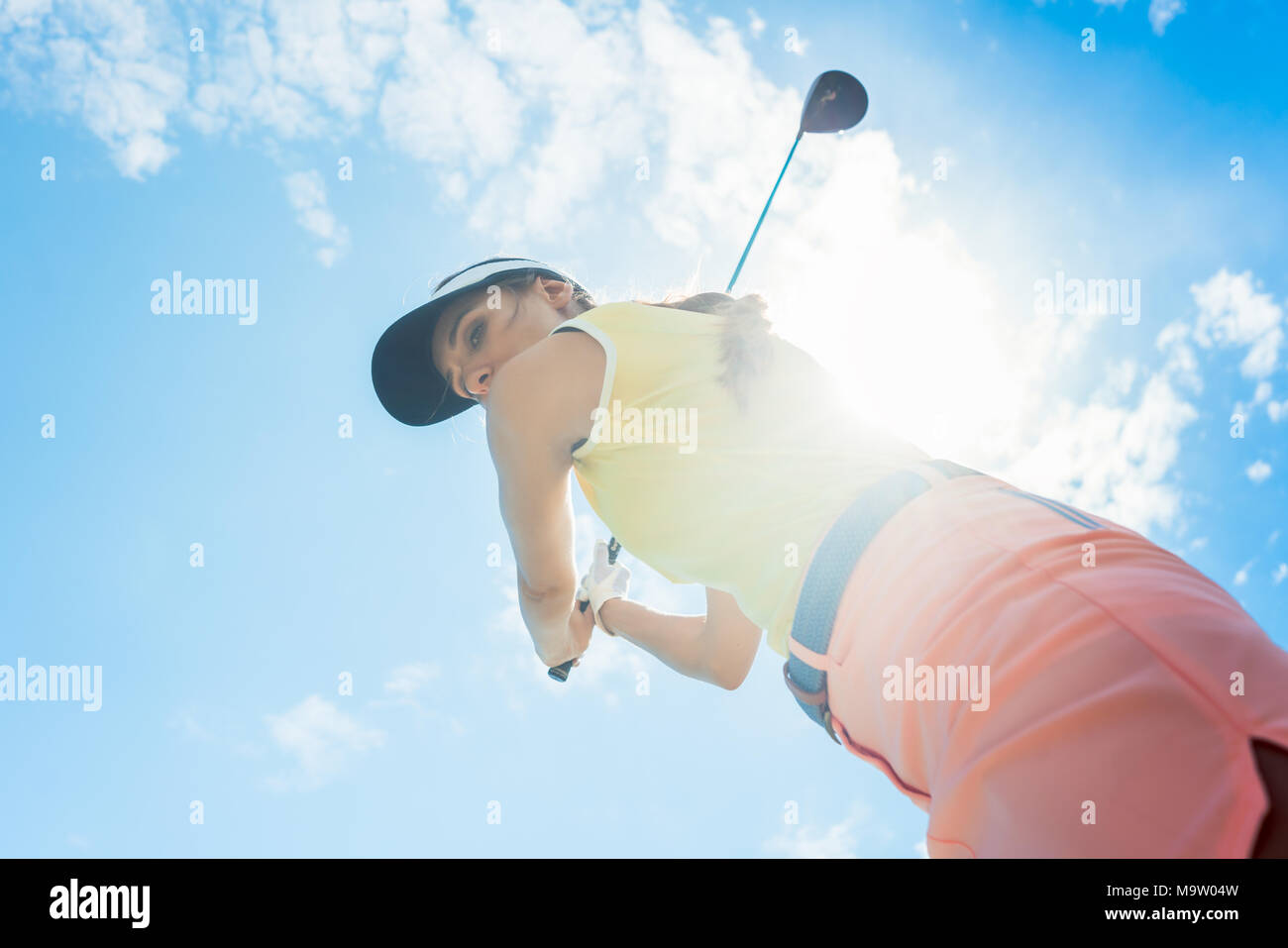 Femmina lettore professionale tenendo il ferro club mentre giocando a golf Foto Stock