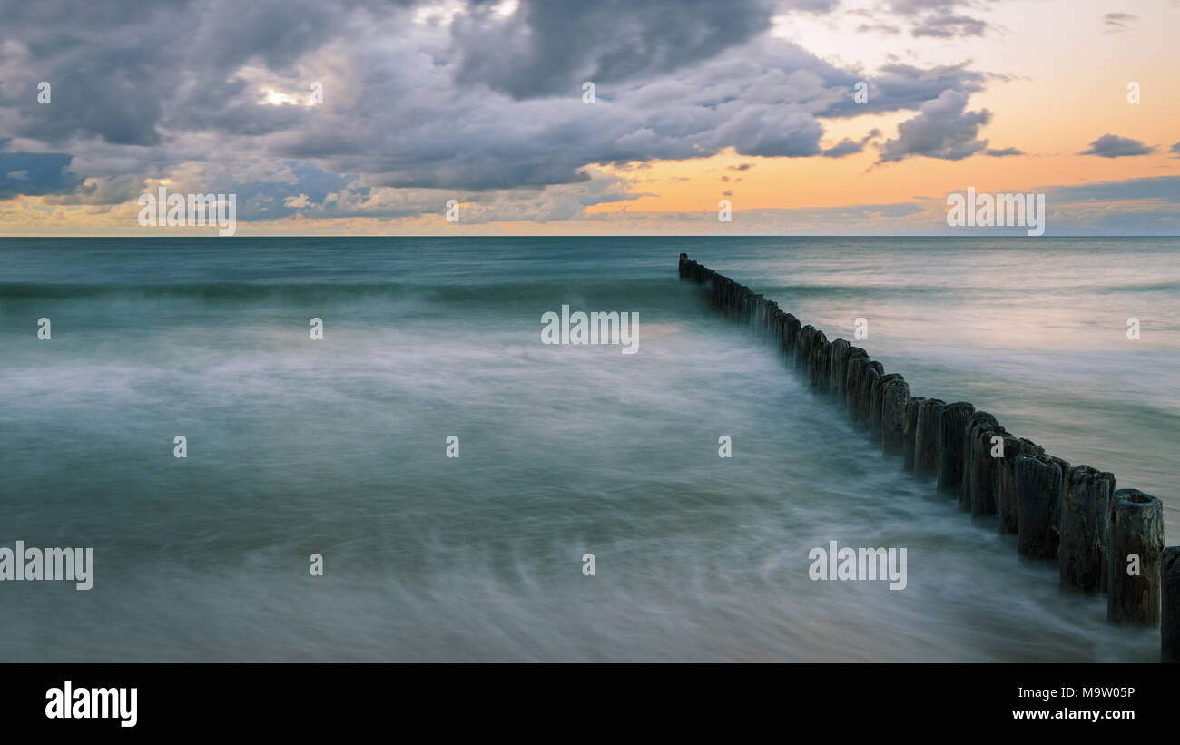 Struttura di frangionde in legno sul Mar Baltico al crepuscolo Foto Stock
