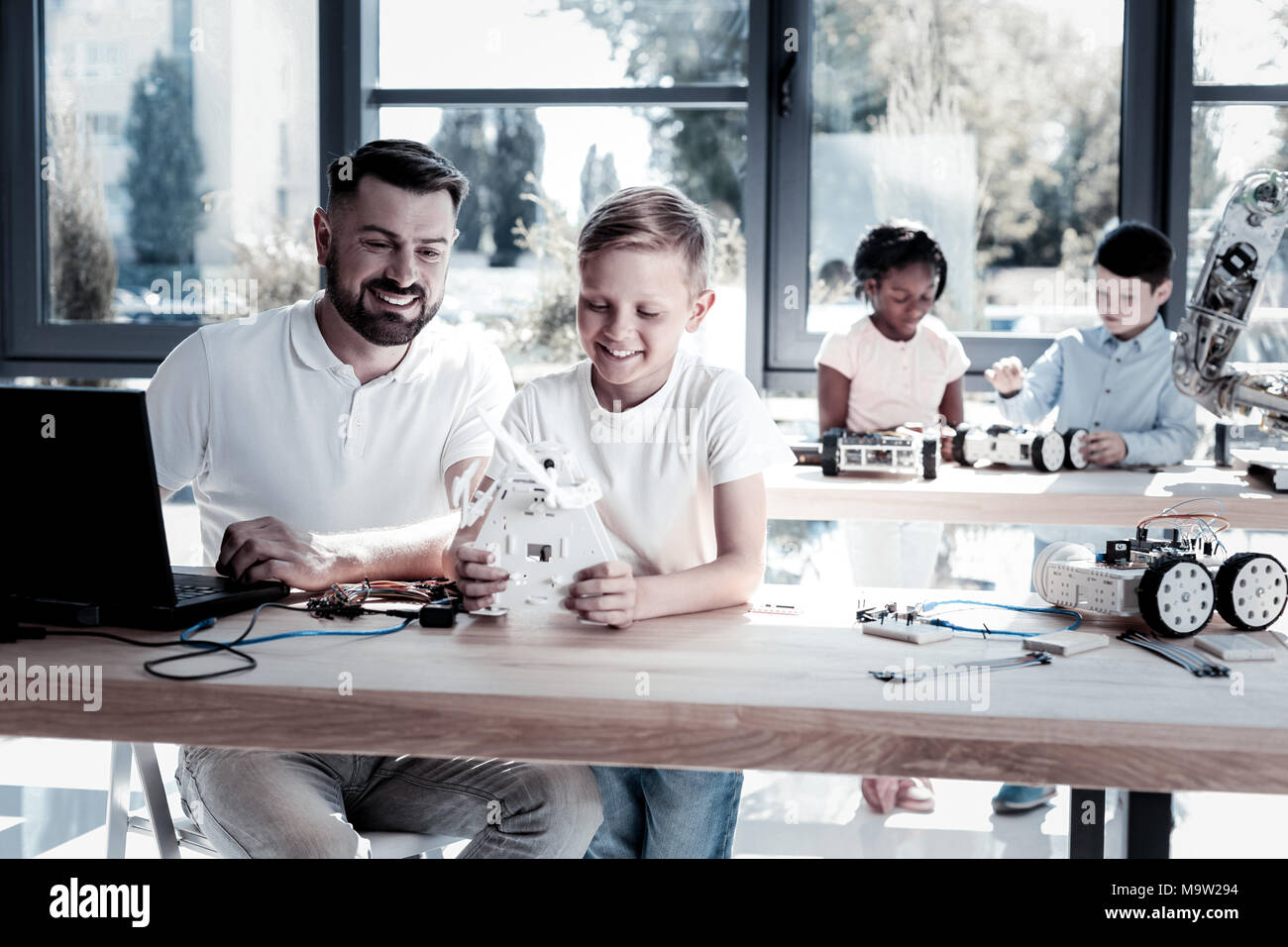 Tecnico di gioiosa e maschio giovane lavorando sulla macchina robotica Foto Stock