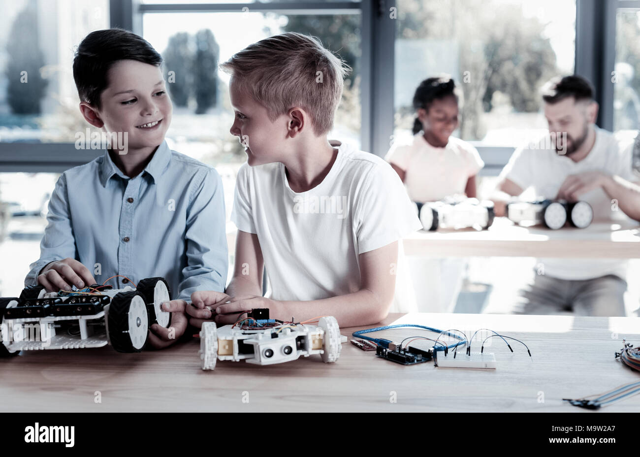 Entusiasti i ragazzi a discutere il loro progetto tecnico insieme Foto Stock