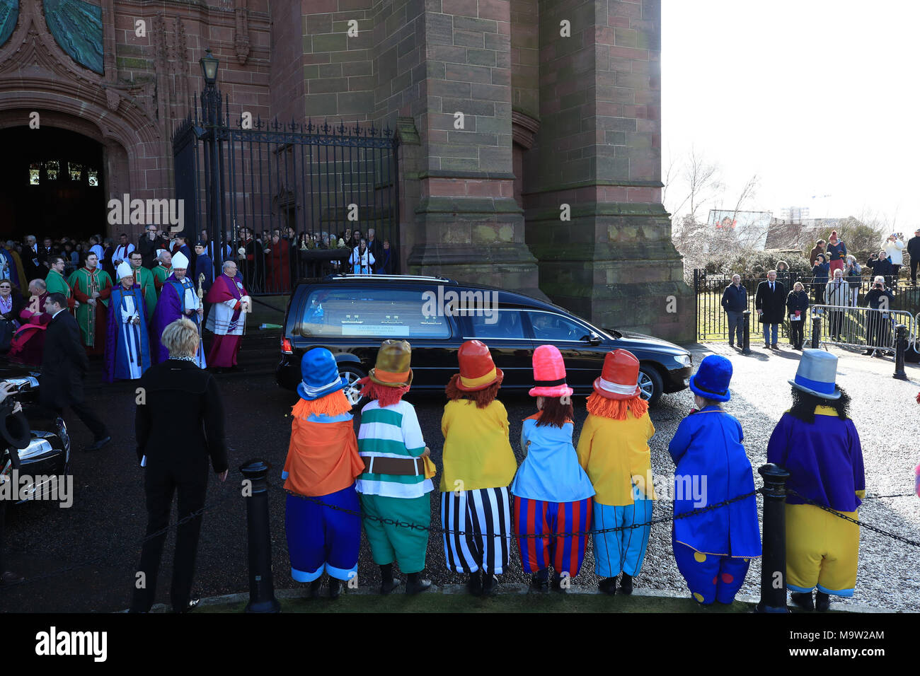 I bambini vestiti da Diddymen guarda il corteo funebre lasciare il Liverpool Cattedrale Anglicana dopo il servizio funebre di Sir Ken Dodd. Foto Stock