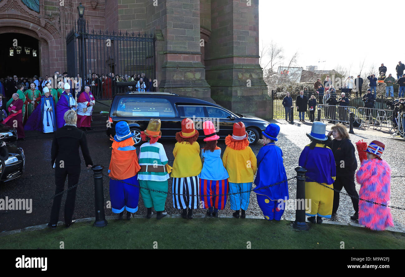 I bambini vestiti da Diddymen guarda il corteo funebre lasciare il Liverpool Cattedrale Anglicana dopo il servizio funebre di Sir Ken Dodd. Foto Stock