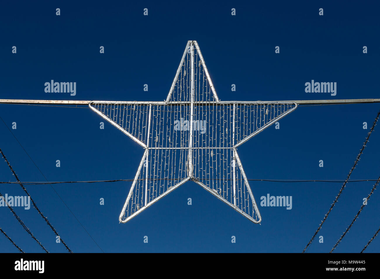 Argento stella di Natale nella parte anteriore del cielo blu. Foto Stock