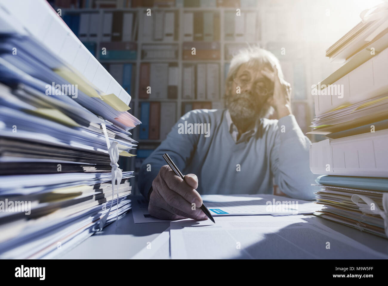 Senior lavoratore di ufficio che mostra un contratto e per chiedere una firma, la burocrazia e gli accordi di concetto Foto Stock