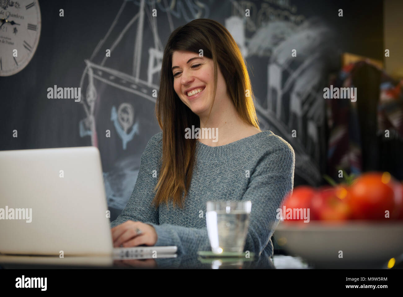 Repentigny,Canada,27,Marzo,2018.giovane donna con il suo computer nella sua cucina navigando in internet.Credit Mario Beauregard/Alamy Live News Foto Stock