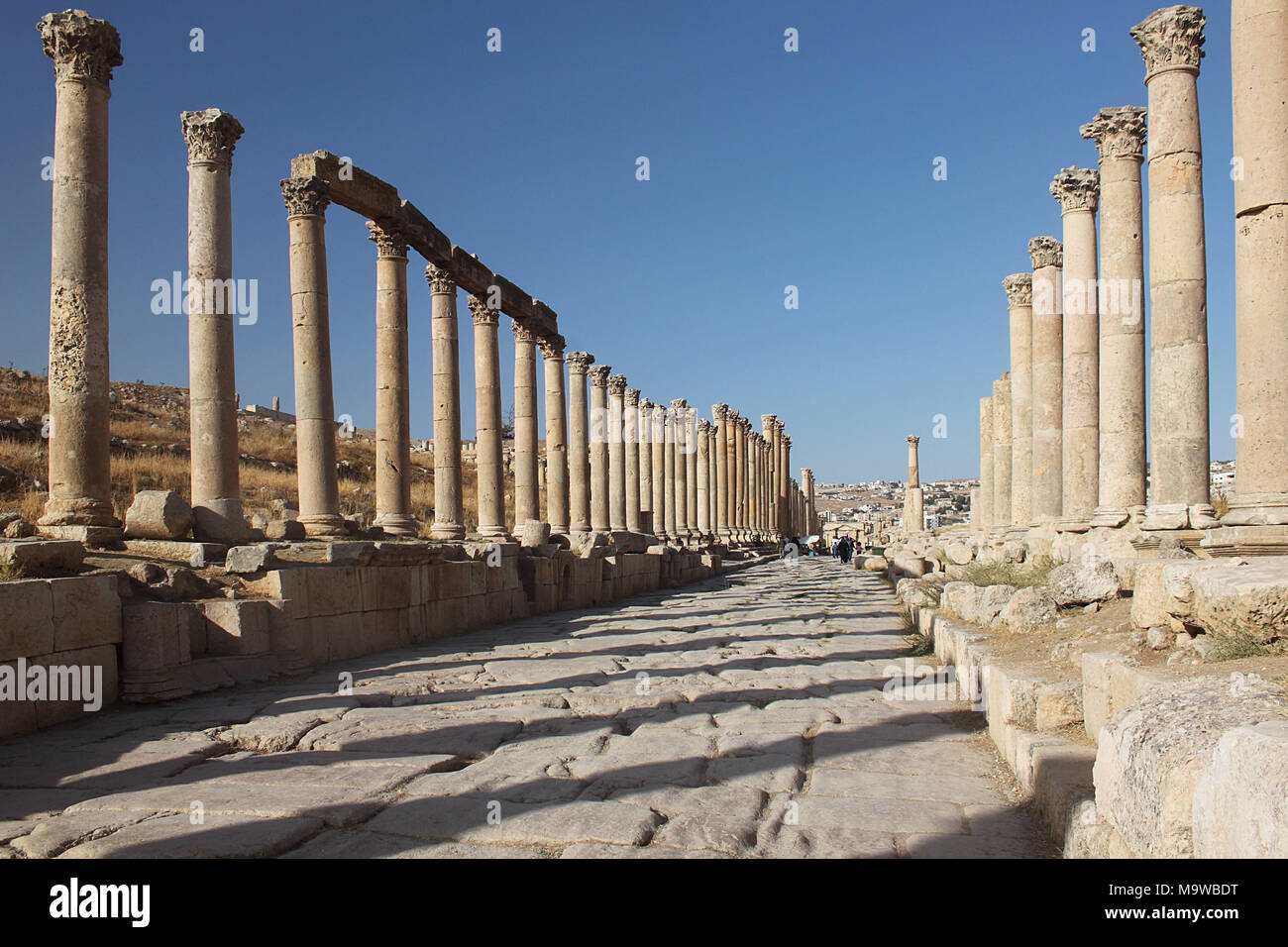 La strada principale (Cardo) in Jerash. Il ben conservato superficie pavimentata mostra ancora le tracce delle ruote di carri che viaggiavano lungo di essa in epoca romana. Foto Stock