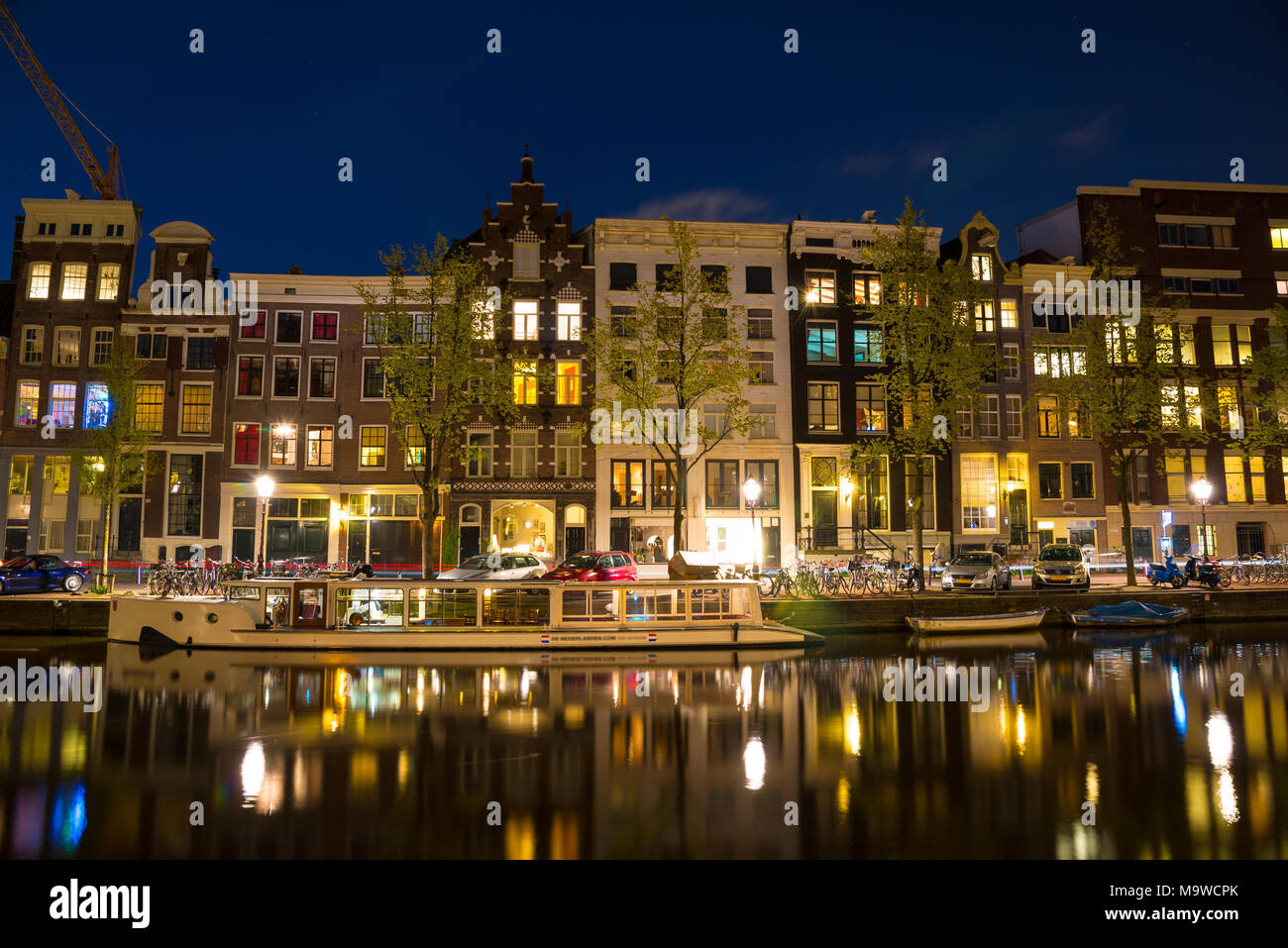 Fiume Amstel, canali e vista notturna della bellissima città di Amsterdam. Paesi Bassi. Foto Stock