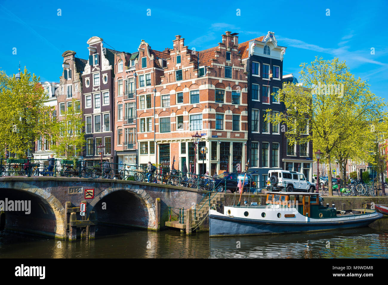 Amsterdam, Paesi Bassi - 20 Aprile 2017: la splendida vista dei canali di Amsterdam con il ponte e il tipico olandese case. Holland Foto Stock