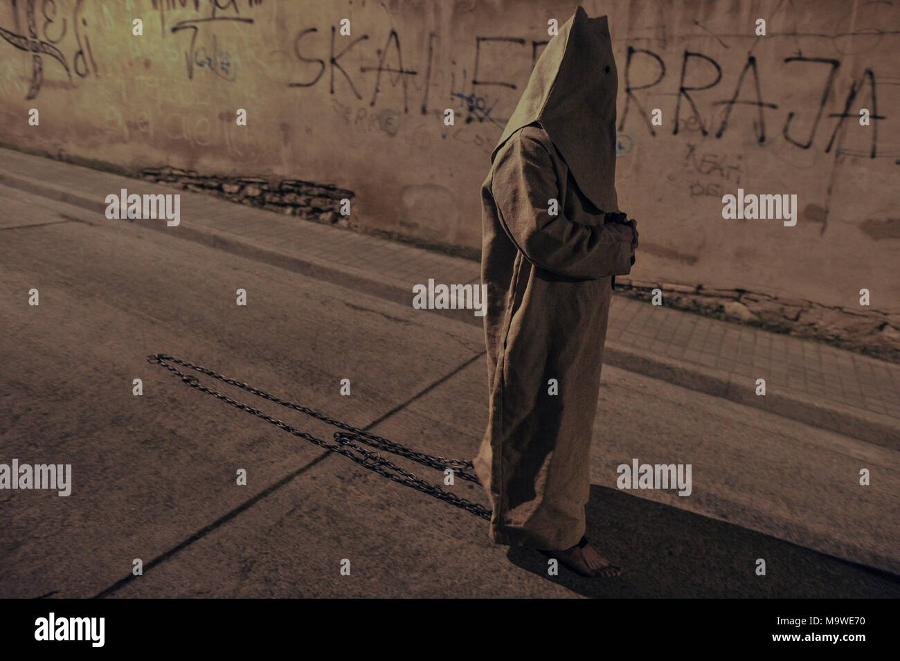 Tarazona, Spagna. 27 Mar, 2018. La confraternita della "Silencio del Santísimo Cristo del rebate, incrociano martedì santo le strade di Tarazona con il 'ensacados'. Si vestono di una tunica fatta di cilicio, camminare a piedi nudi e con catene collegate alle loro caviglie. Credito: Oscar Zubiri/Pacific Press/Alamy Live News Foto Stock
