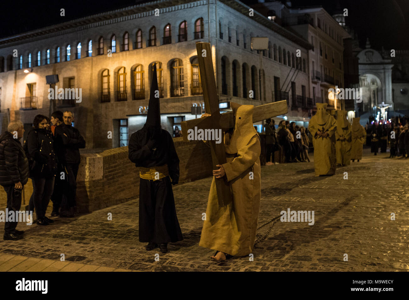 Tarazona, Spagna. 27 Mar, 2018. La confraternita della "Silencio del Santísimo Cristo del rebate, incrociano martedì santo le strade di Tarazona con il 'ensacados'. Si vestono di una tunica fatta di cilicio, camminare a piedi nudi e con catene collegate alle loro caviglie. Credito: Oscar Zubiri/Pacific Press/Alamy Live News Foto Stock