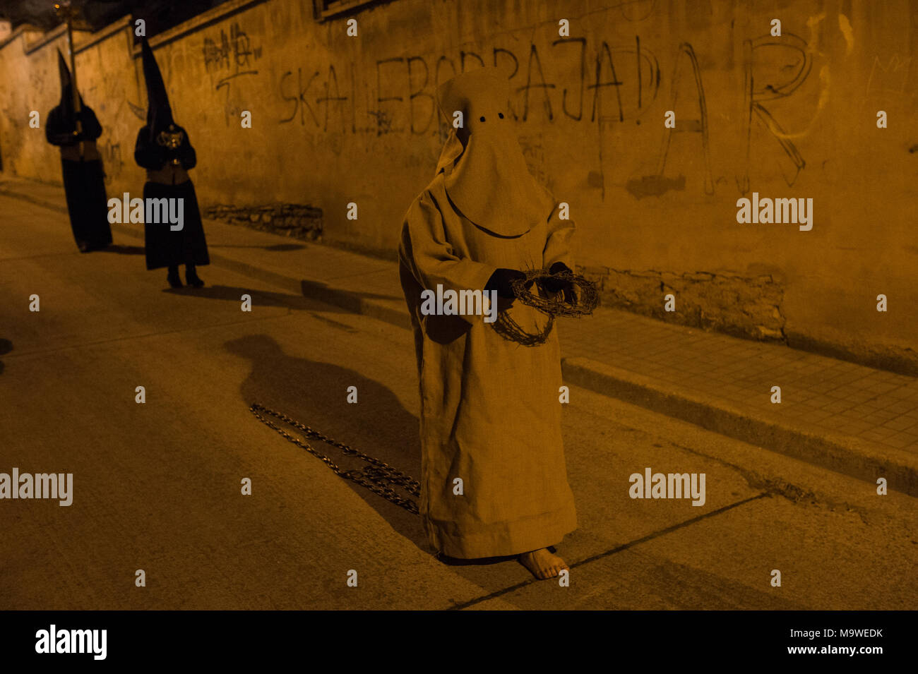 Tarazona, Spagna. 27 Mar, 2018. La confraternita della "Silencio del Santísimo Cristo del rebate, incrociano martedì santo le strade di Tarazona con il 'ensacados'. Si vestono di una tunica fatta di cilicio, camminare a piedi nudi e con catene collegate alle loro caviglie. Credito: Oscar Zubiri/Pacific Press/Alamy Live News Foto Stock