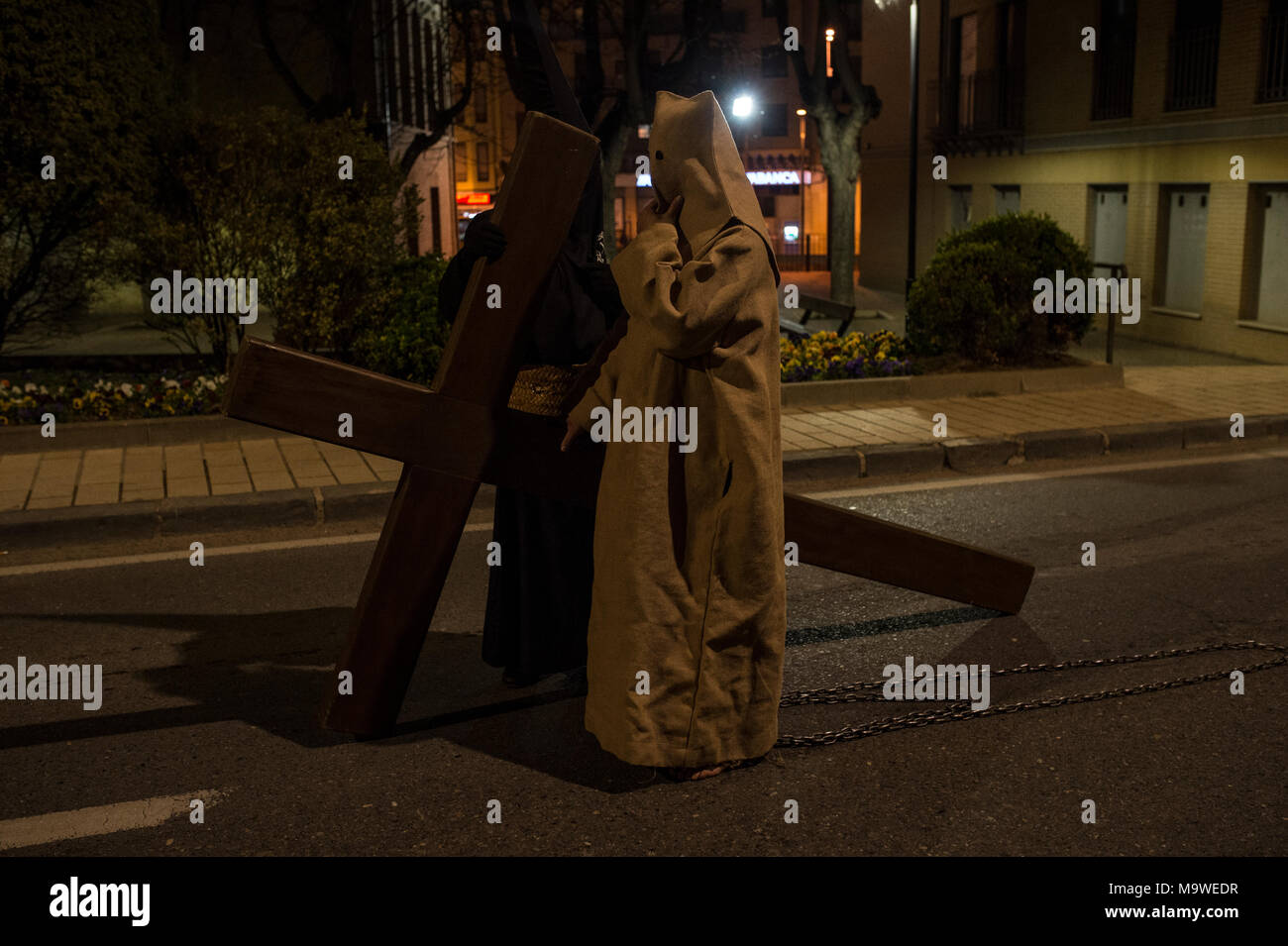 Tarazona, Spagna. 27 Mar, 2018. La confraternita della "Silencio del Santísimo Cristo del rebate, incrociano martedì santo le strade di Tarazona con il 'ensacados'. Si vestono di una tunica fatta di cilicio, camminare a piedi nudi e con catene collegate alle loro caviglie. Credito: Oscar Zubiri/Pacific Press/Alamy Live News Foto Stock