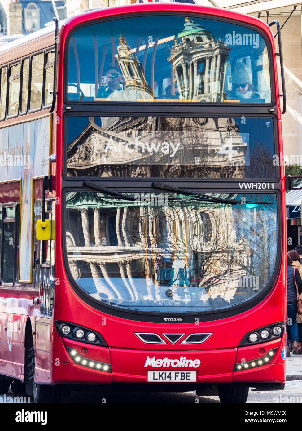 La Cattedrale di St Paul e riflessa nei vetri anteriori di un rosso London bus Foto Stock