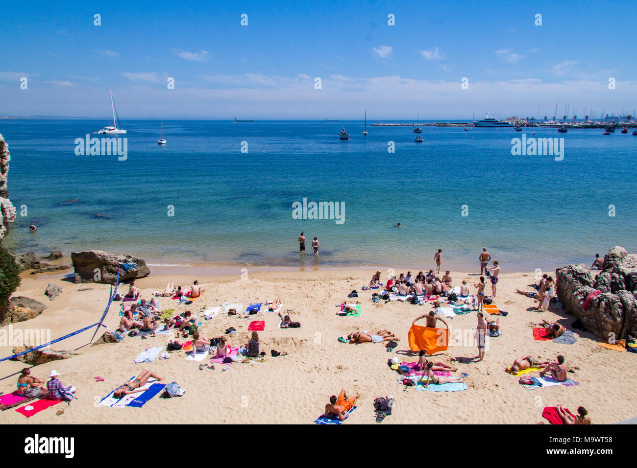 La gente a prendere il sole sulla spiaggia a Cascais, Portogallo Foto Stock